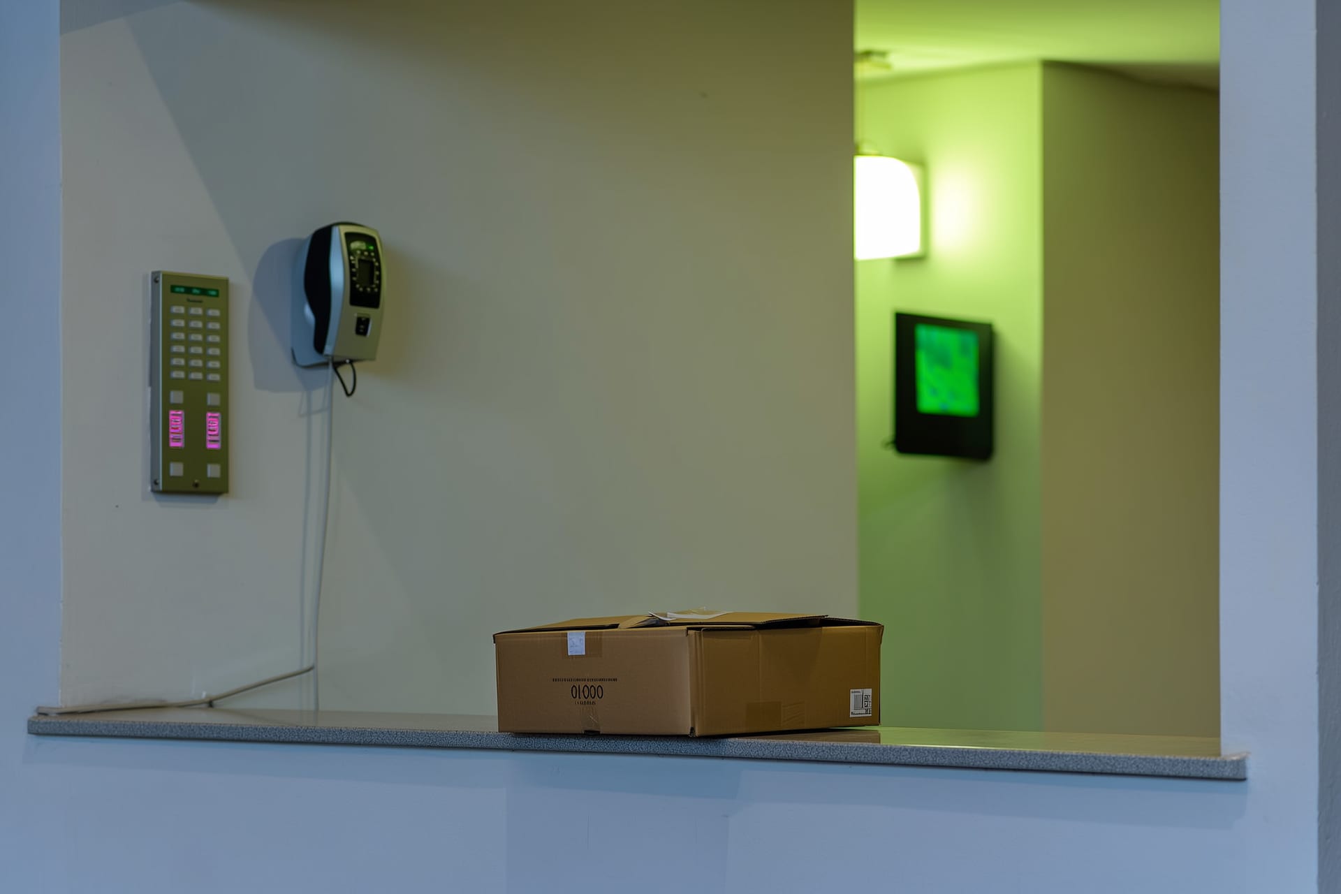 Portaria vazia de um condomínio sem porteiro 24 horas, com uma encomenda deixada no balcão